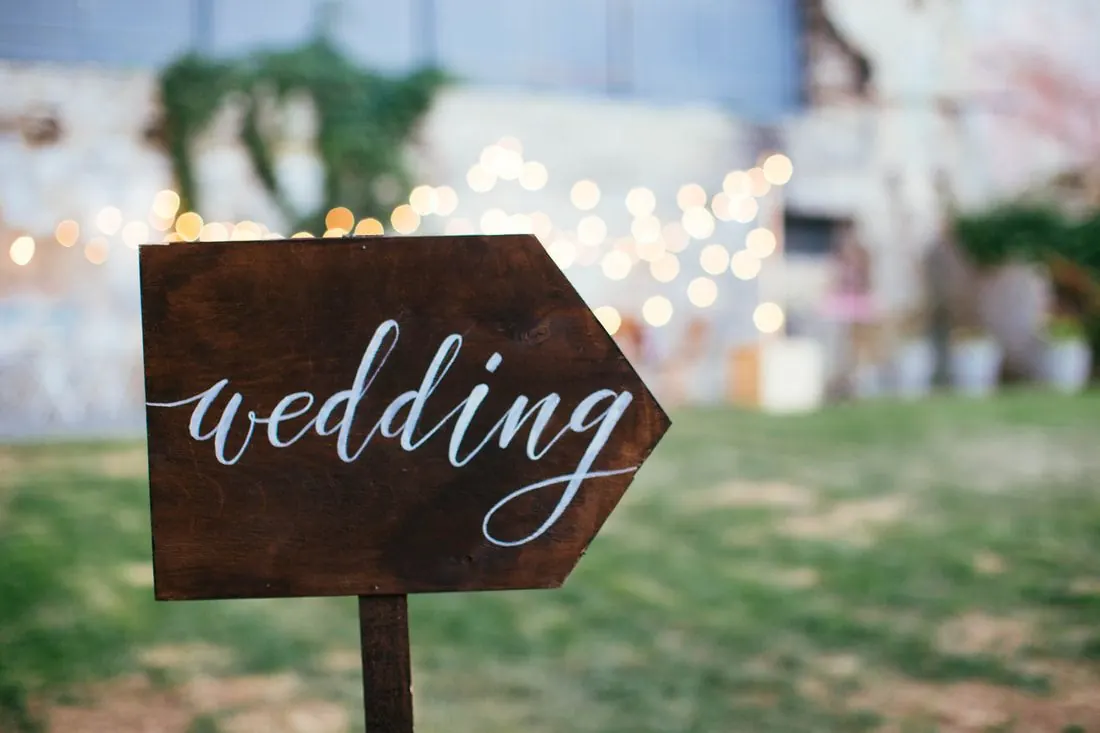 Wooden wedding sign under string lights